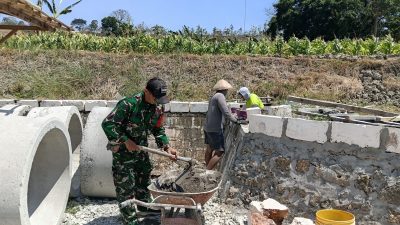 Perkuat Kemanunggalan TNI dengan Rakyat, Babinsa Koramil Ngluyu Bantu Pembangunan Pagar di Desa Bajang